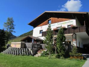 a large white building with a wooden roof at Haus Sonnenalm in Sankt Sigmund im Sellrain