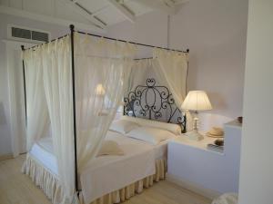 イドラにあるHouse Aquataのベッドルーム(白いシーツを使用した天蓋付きベッド1台付)