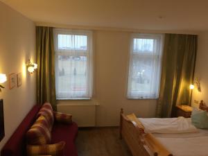 a bedroom with a bed and two windows at Fürstenhof Landgasthaus & Hotel in Erfurt