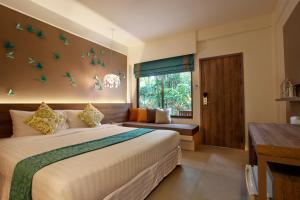 Un dormitorio con una cama grande y una ventana en The Viridian Resort - SHA Plus, en Patong Beach