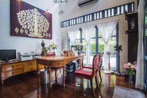 a home office with a desk and a red chair at Baan Noppawong in Bangkok