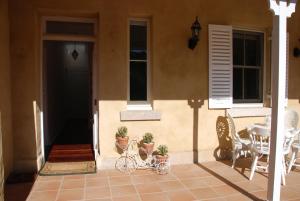 a house with a patio with a table and chairs at Hillside Cottage Berrima in Berrima +10 photos