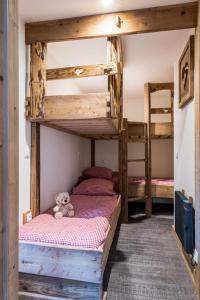 two bunk beds in a room with a teddy bear at Meribel 17 in Méribel