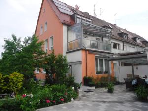 ein Apartmentgebäude mit einer Terrasse und Pflanzen in der Unterkunft Ferienhaus Gumann in Nürnberg