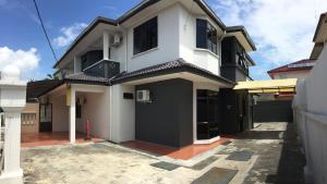 a white house with a black garage at Homestay Muar in Muar