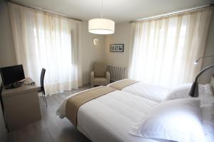 Un dormitorio con una cama y un escritorio con televisión. en Los Guardeses, en Solares