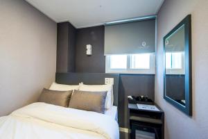a small room with two beds and a television at Philstay Myeongdong Metro in Seoul