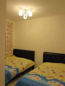 - une chambre avec deux lits jumeaux et une lumière dans l'établissement SA Apartments @ Crown Imperial Court, à Cameron Highlands