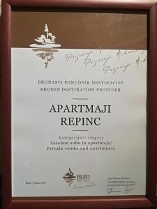 a framed diploma with a sign in a wooden frame at Apartments Repinc in Bled