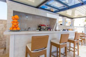 a bar with chairs and a counter with oranges on it at Luxury Aparthotel in Makarska