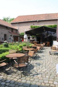 een groep tafels en stoelen voor een gebouw bij Het Pachthof in Borlo