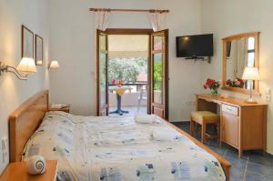 a bedroom with a bed and a desk and a television at Hotel Apartments Sikia in Kato Gatzea