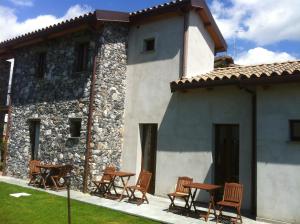 a building with chairs and tables in front of it at Il Casale Del Giglio in Santo Stefano di Magra