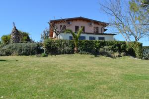 a house behind a hedge in a yard at Country House Il Papavero Rosso in Francavilla al Mare