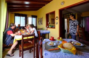Eine Gruppe von Menschen, die an einem Tisch sitzen und essen in der Unterkunft Casa Comba in Mindelo