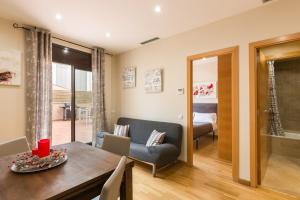 a living room with a dining room table and a bedroom at Matarolux 8 in Mataró