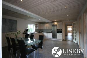 una cucina e una sala da pranzo con tavolo e sedie di Liseby Bed & Breakfast a Stege