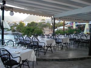 a group of tables and chairs with white table cloths at Panorama Hotel in Agia Marina Aegina