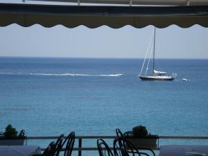 a sailboat in the ocean with a boat in the water at Panorama Hotel in Agia Marina Aegina