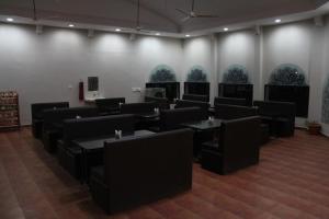 um restaurante com mesas pretas e cadeiras numa sala em Goflamingo Resort em Silāri