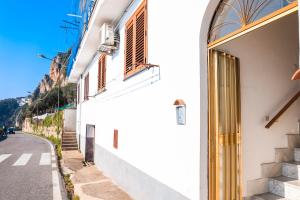 a white building with a door on the side of a street at La Casetta in Amalfi