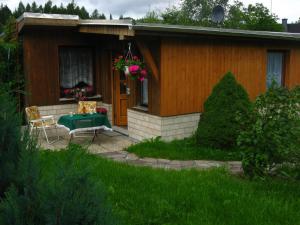 ein kleines Haus mit einem grünen Tisch und Stühlen im Freien in der Unterkunft Ferienhaus Kohlmeise in Neudorf