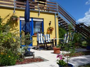 eine Terrasse mit 2 Stühlen und einem Sonnenschirm in der Unterkunft Ferienhaus Käpt´n Moritz in Ostseebad Karlshagen