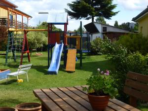 einen Hinterhof mit einem Spielplatz mit Rutsche in der Unterkunft Ferienhaus Käpt´n Moritz in Ostseebad Karlshagen