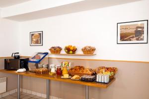 un comptoir contenant du pain et des paniers de nourriture dans l'établissement Séjours & Affaires Orléans Jeanne D'Arc, à Orléans