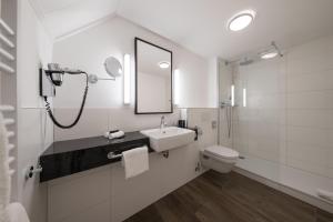 a bathroom with a toilet, sink, and mirror at Hotel De Bilderberg in Oosterbeek