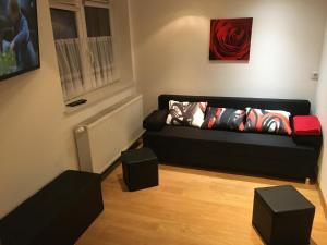 a living room with a black couch and a window at Miniappartement Zini in Lindlar