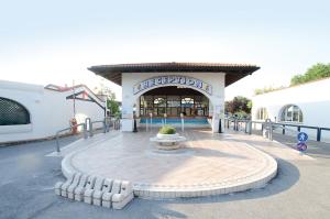 a building with a fountain in the middle of a street at Villaggio San Francesco in Duna Verde