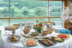a buffet of food on a white table with a window at Satorikan in Gosen