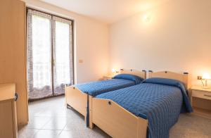 a bedroom with two beds and a large window at Casa Lori Green Holiday in Ledro