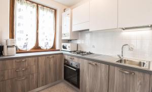 a kitchen with wooden cabinets and a sink at Casa Lori Green Holiday in Ledro +16 photos