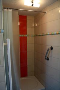 uma casa de banho com uma banheira e um chuveiro com uma faixa vermelha em Pavillon an der Ilm em Ilmenau