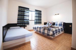 a bedroom with two beds and a couch at Apartamentos Alberto S.L. in Morro del Jable