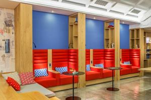 un restaurante con asientos rojos y paredes azules en Airotel Alexandros en Atenas
