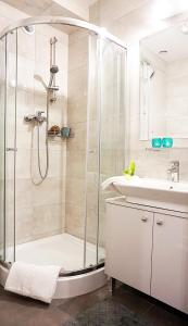 La salle de bains est pourvue d'une douche et d'un lavabo. dans l'établissement DK Apartament Grunwaldzki, à Olsztyn