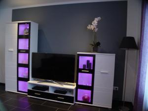 um centro de entretenimento com uma televisão de ecrã plano numa sala de estar em La Domus Superior Osnabrück Lotte em Osnabrück