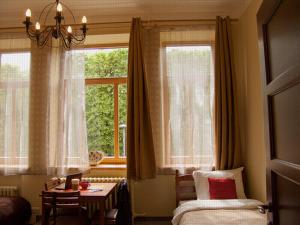 Hostel Lux في كاوناس: غرفة نوم بسرير وطاولة ونافذة