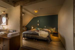 1 dormitorio con 1 cama con pared verde en Samsam, en Meerssen