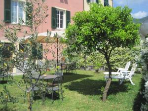 un patio con sillas, una mesa y un árbol en B&B Fattore, en Levanto