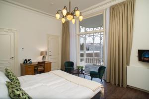 a bedroom with a bed and a large window at Boutique Hotel De Blauwe Pauw in Den Bosch