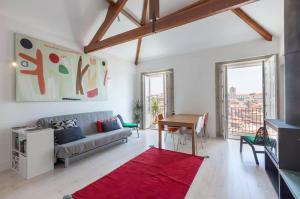 a living room with a couch and a red rug at Boutique Rentals - Hidden Treasure in Porto