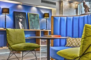 a living room filled with furniture and a blue wall at Airotel Alexandros in Athens