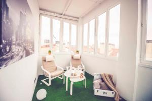 Habitación con mesa, sillas y ventanas. en Hostal Lisboa, en Madrid