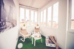 Una habitación con una mesa y sillas y ventanas. en Hostal Lisboa, en Madrid