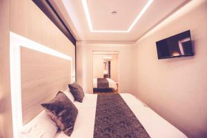una habitación de hotel con una cama y un televisor en Hostal Lisboa, en Madrid