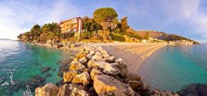 a beach with rocks in the water at Apartments Tonka in Mošćenička Draga
